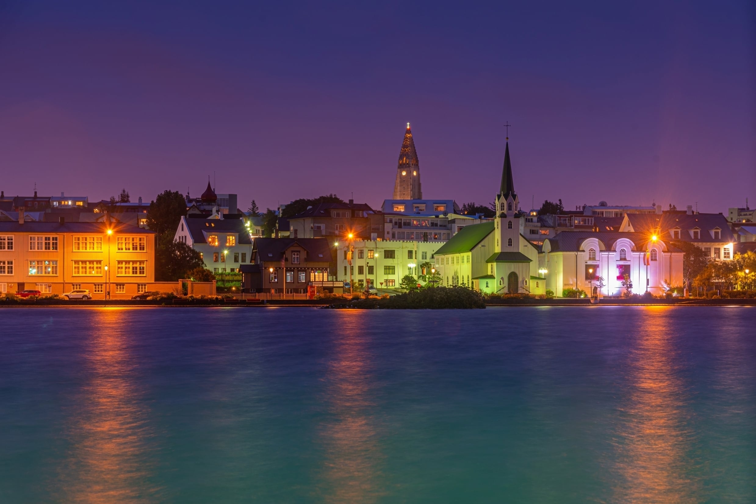 Night view free lutheran church and Hallgrimskirkja cathedral over the water in Reykjavik