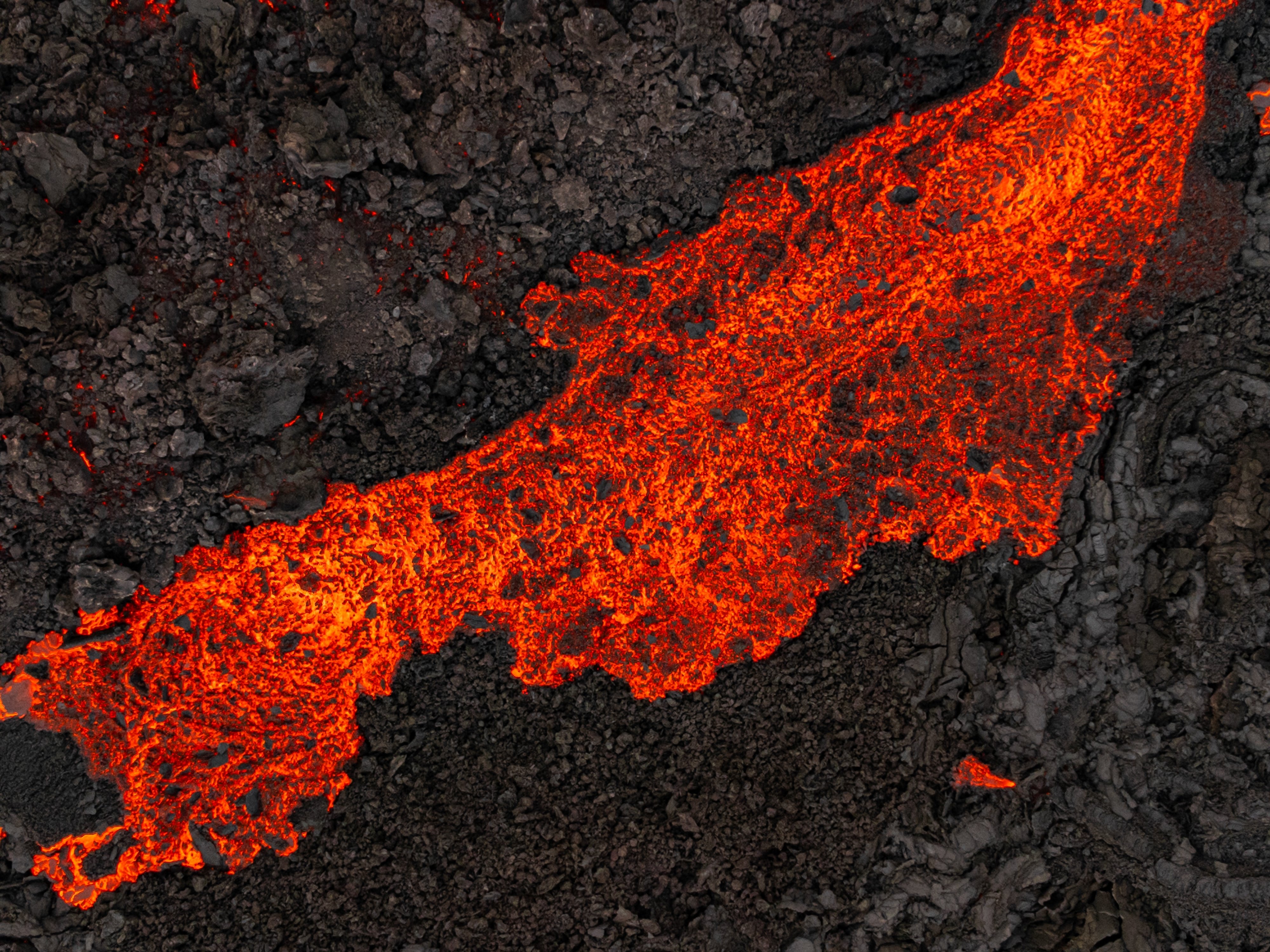 Red lava on black volcanic landscape