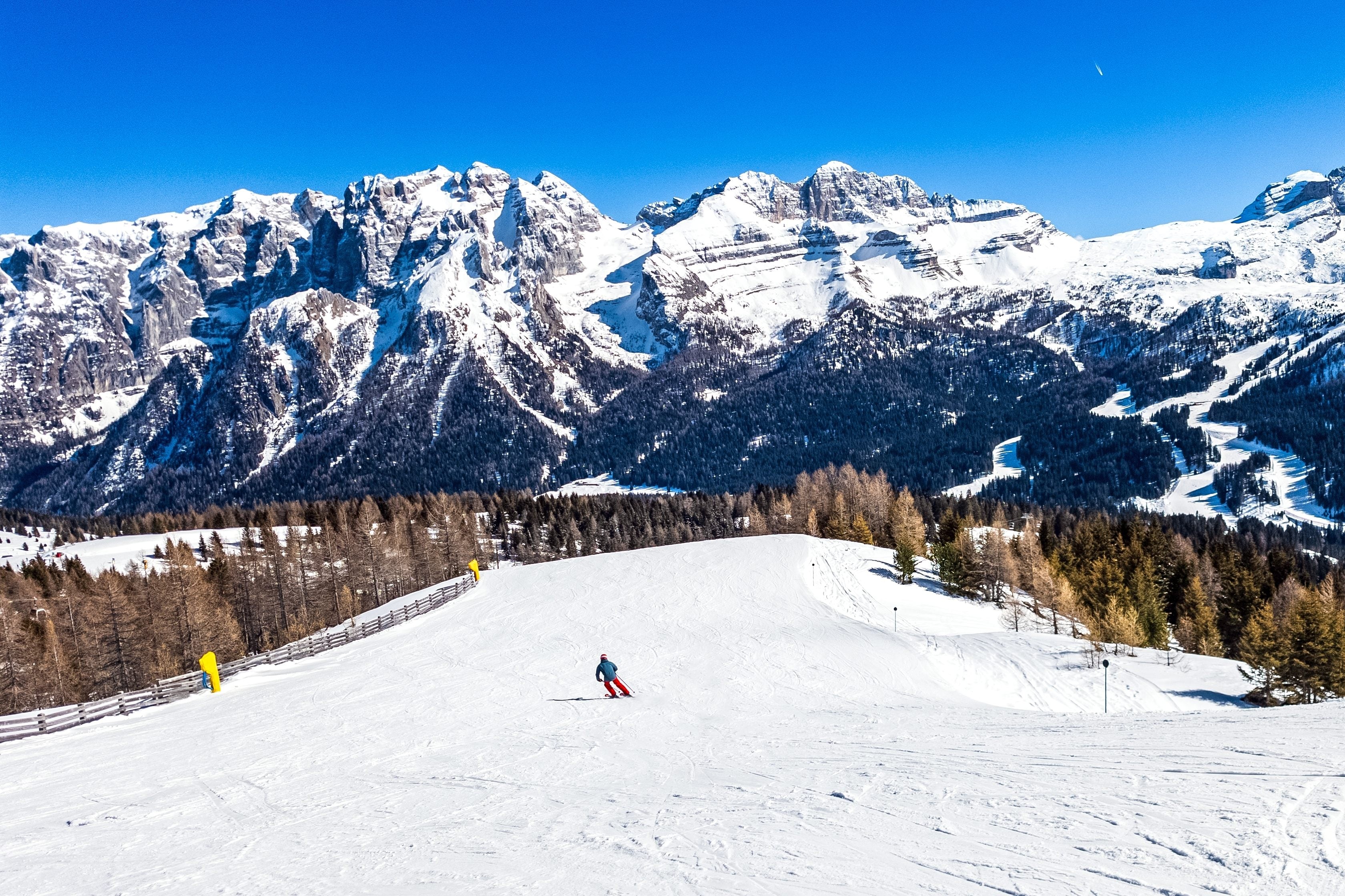 Skier skiing down slope at Madonna di Campiglio ski resort