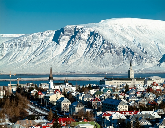 Colourful buildings of Reykjavik, the capital of Iceland, backed by a lake and snowy mountains