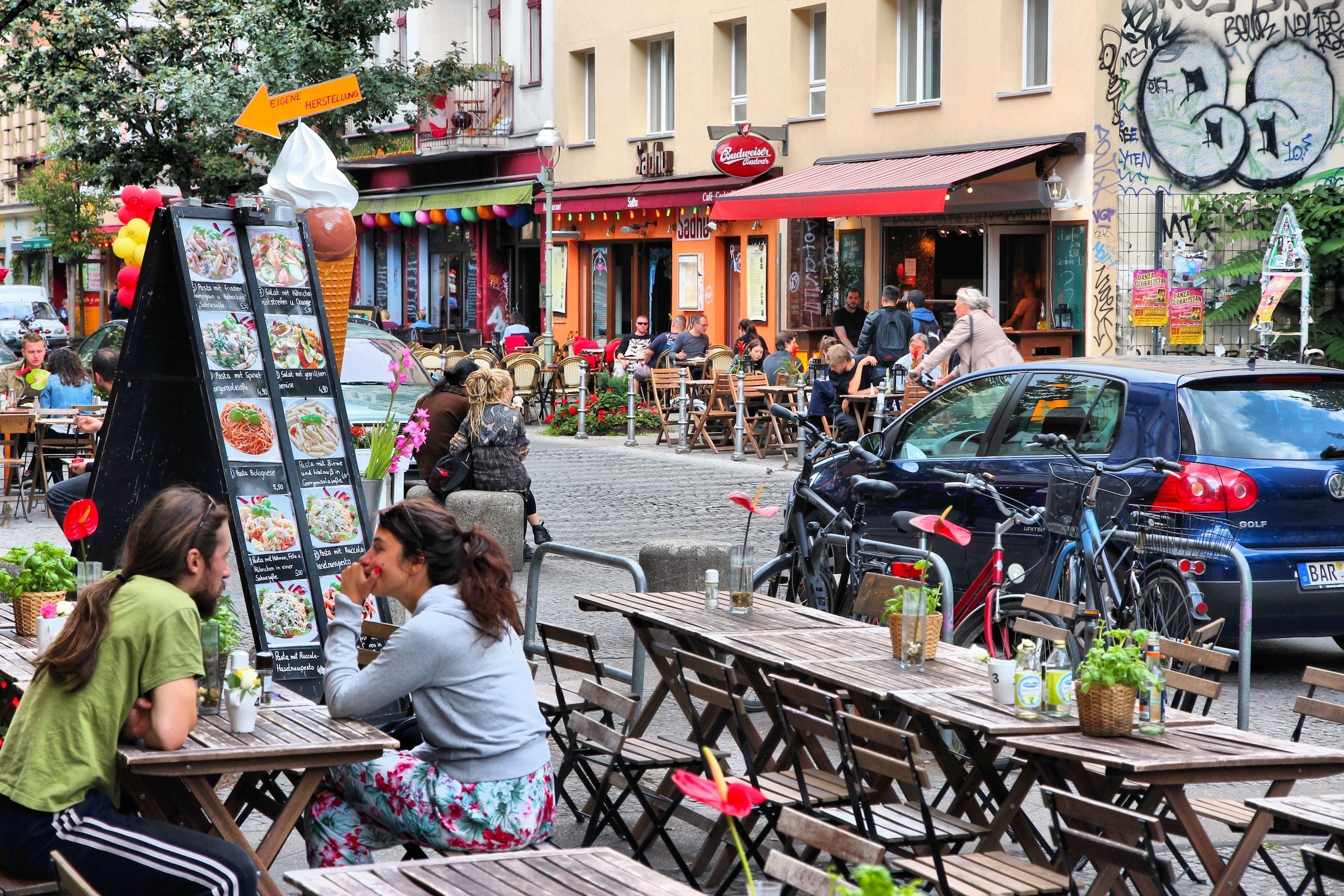Couple dining at outdoor restaurant on a sunny day in Berlin, Germany