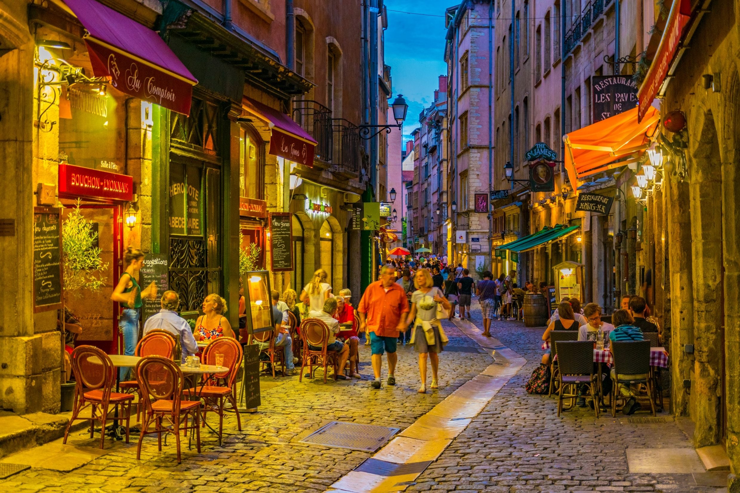 Low lit street with bistro chairs in Lyon, France