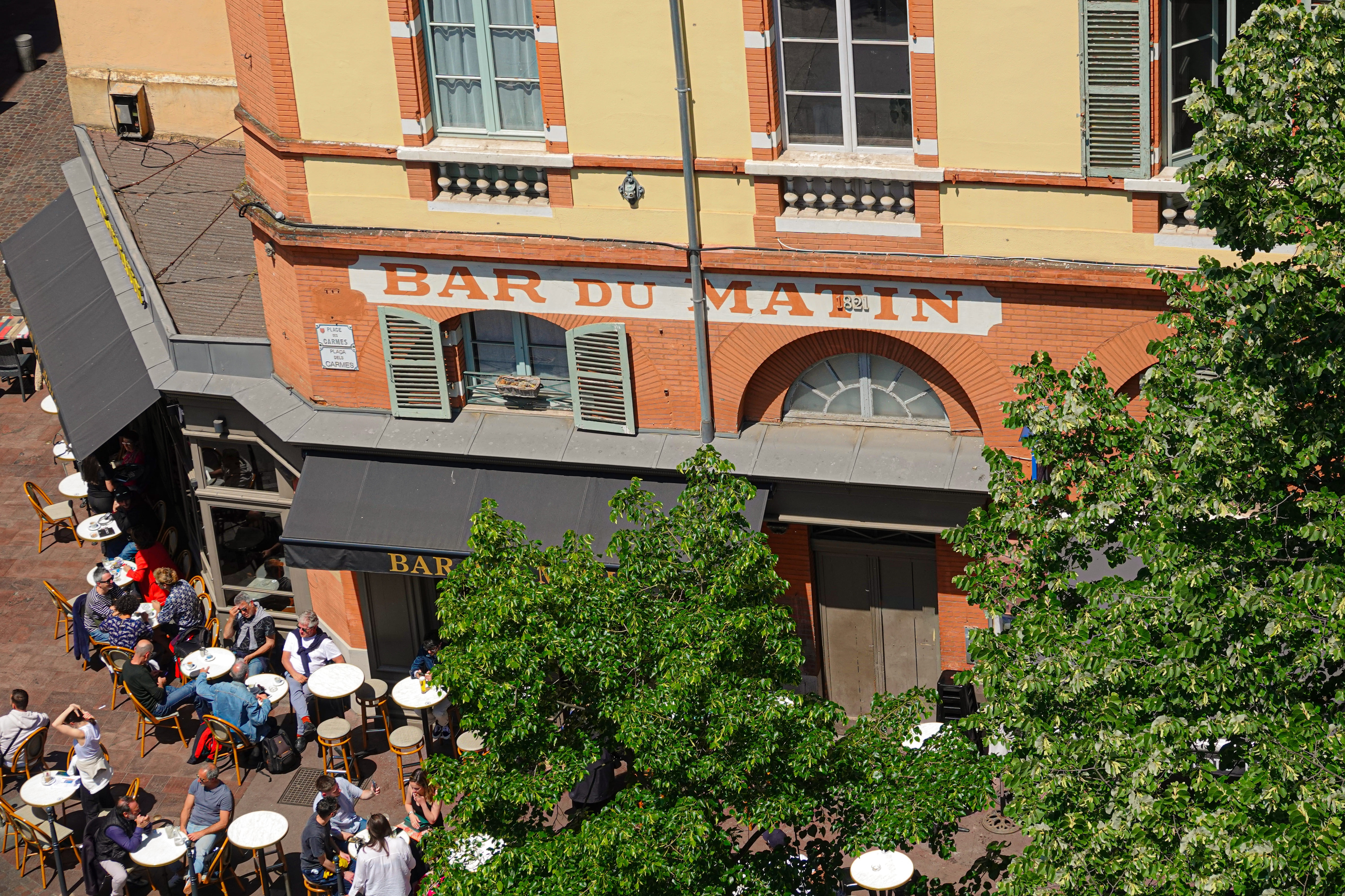 Patrons gather at tables outside Bar du Matin in Toulouse, France