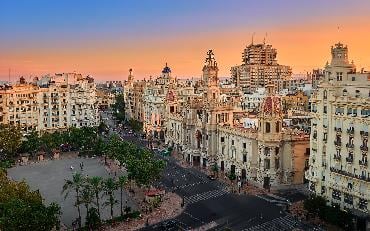 Aerial view of the old Town Hall and its square, North Station and other historic buildings in the area, at sunset in Valencia, Spain